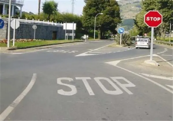 Imagen de apoyo para la pregunta: Para obedecer esta señal de stop, ¿dónde debe detenerse si existe suficiente visibilidad?